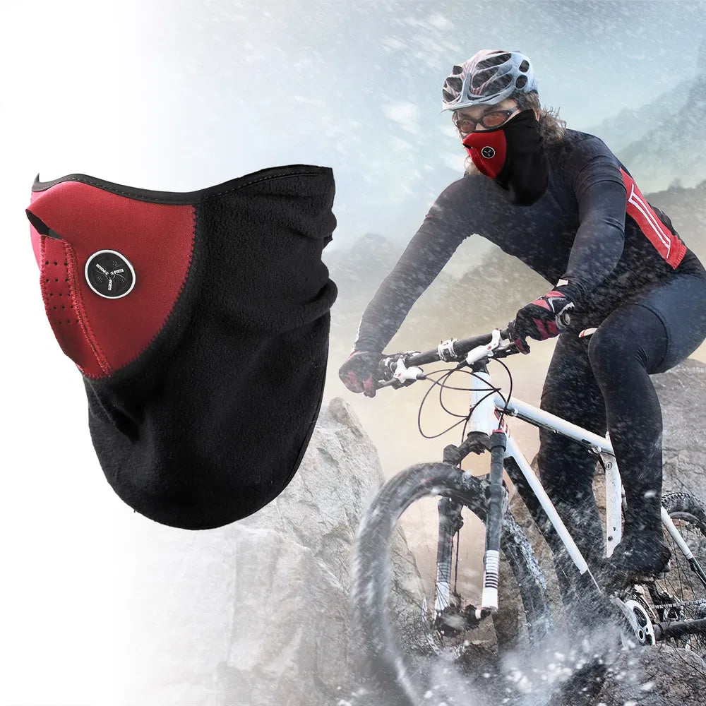 Person mountain biking in snowy conditions wearing a black and red face mask.