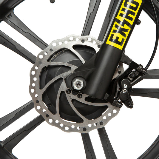 Close-up of a bicycle wheel with disc brake system and Exuvia branding.