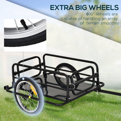 Black bike trailer with large wheels on grass, highlighting its capability to handle various terrains.