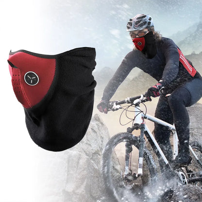 Person mountain biking in snowy conditions wearing a black and red face mask.