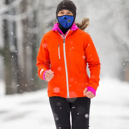Person wearing an orange jacket and blue face mask in a snowy landscape