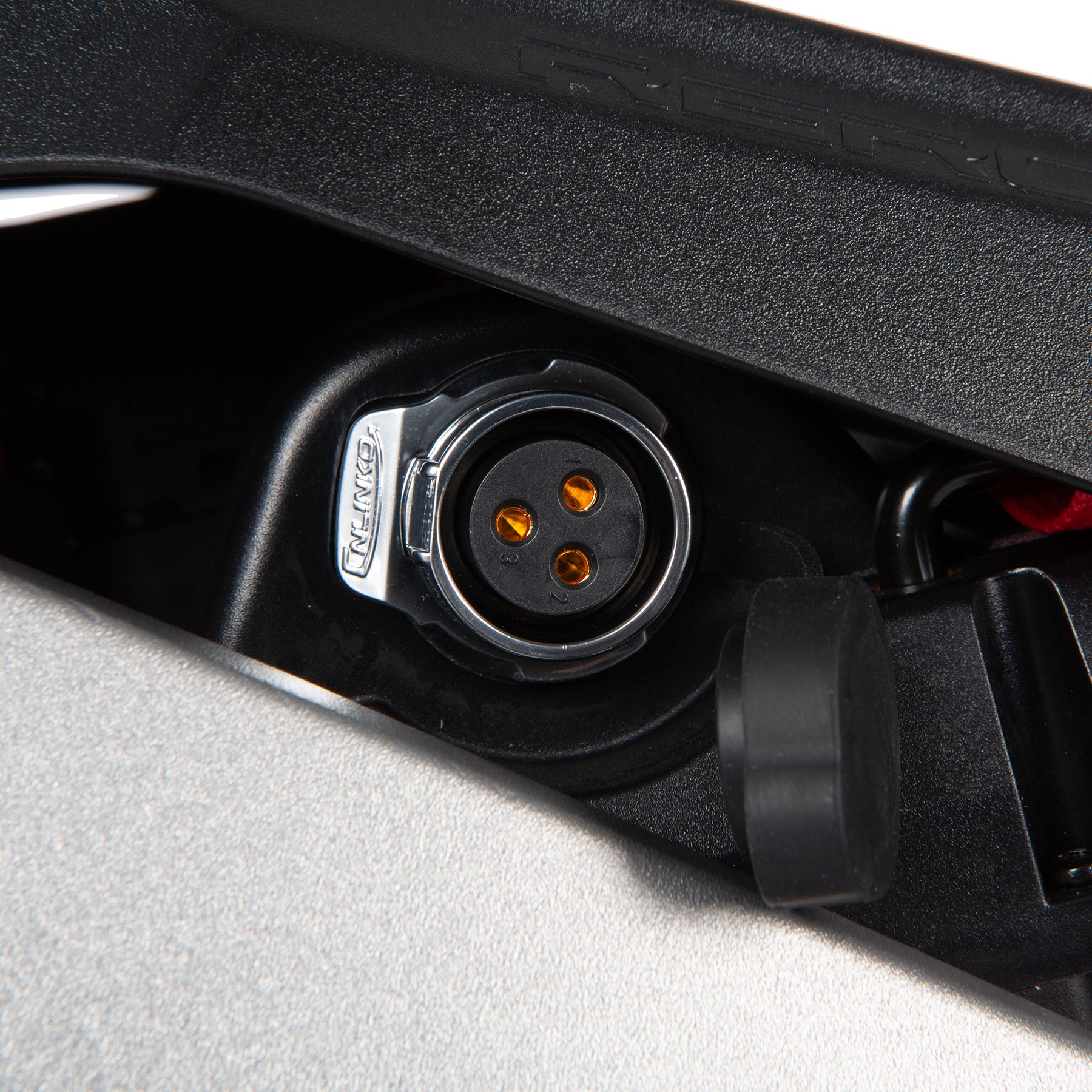 Close-up of a black electrical connector with visible brand logo on a gray background