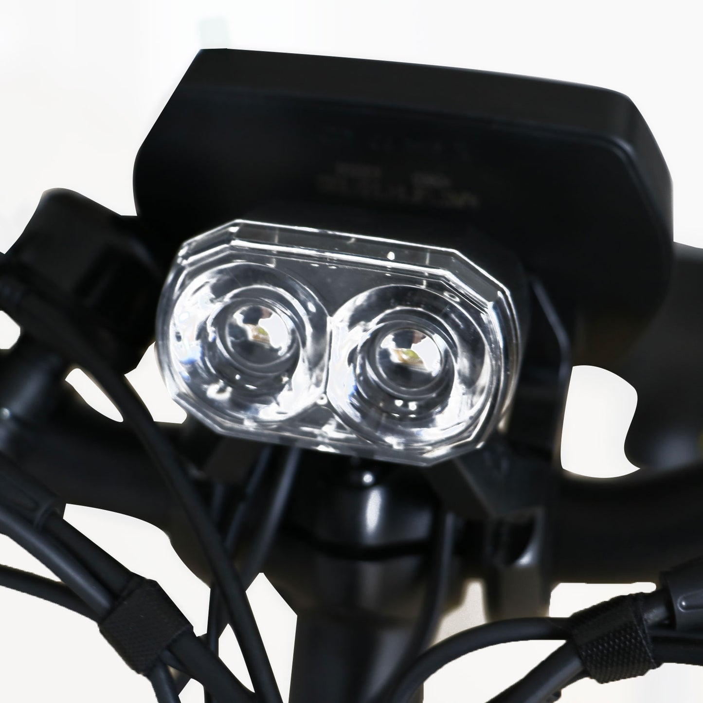 Close-up of a motorcycle headlight with clear cover and black casing.