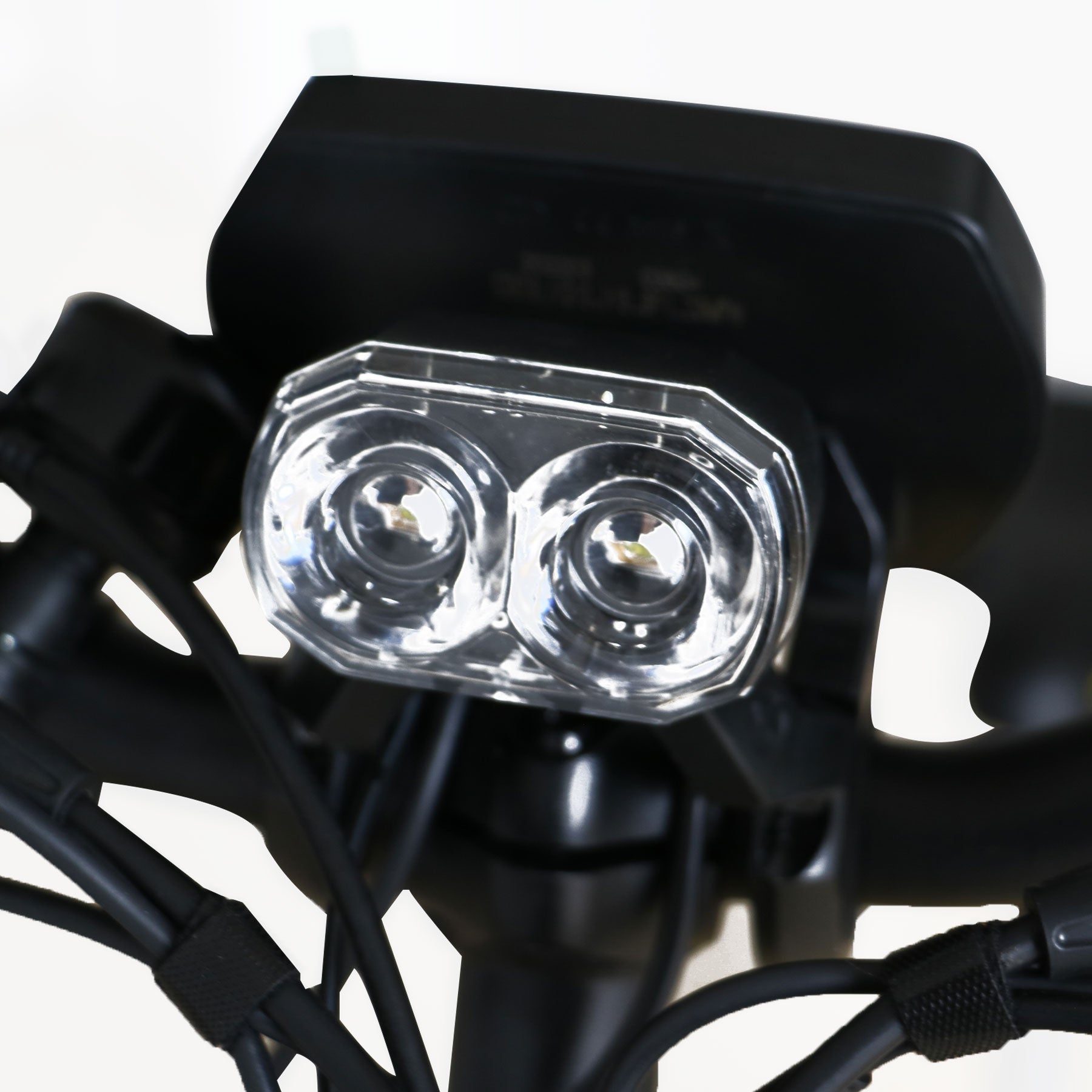Close-up of a motorcycle headlight with clear cover and black casing.