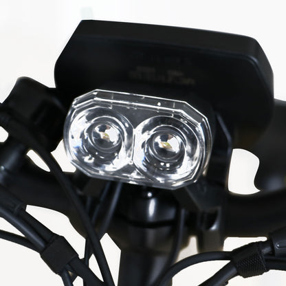 Close-up of a motorcycle headlight with clear cover and black casing.
