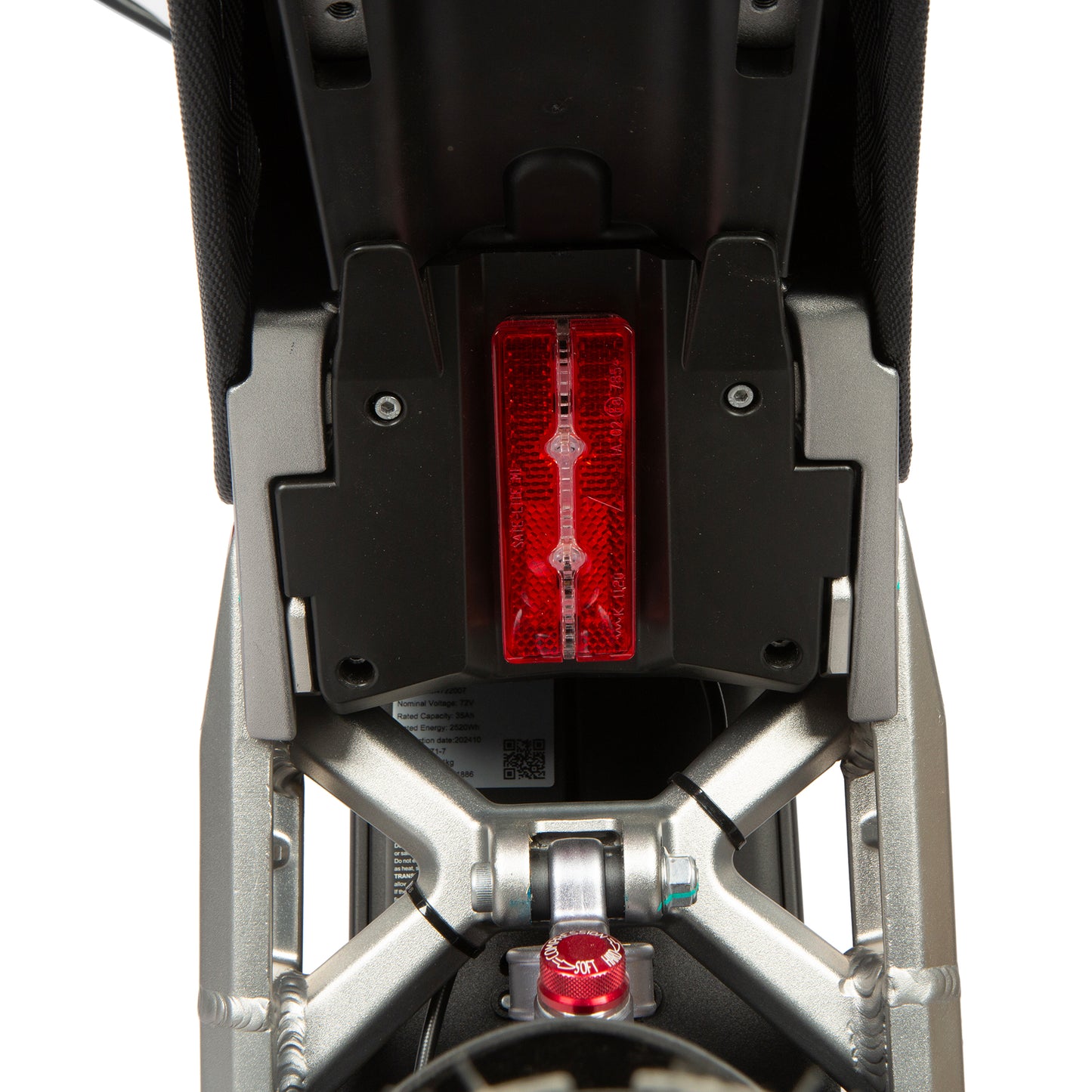 Close-up of a motorcycle's red taillight on a white background