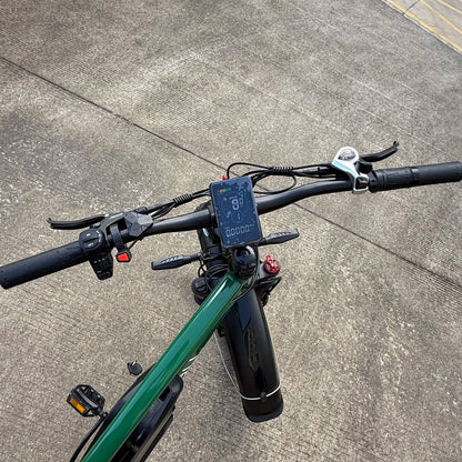 Close-up of an electric bike handlebar with a digital display on a concrete surface