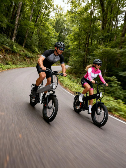 Two people riding electric bikes on a forest road