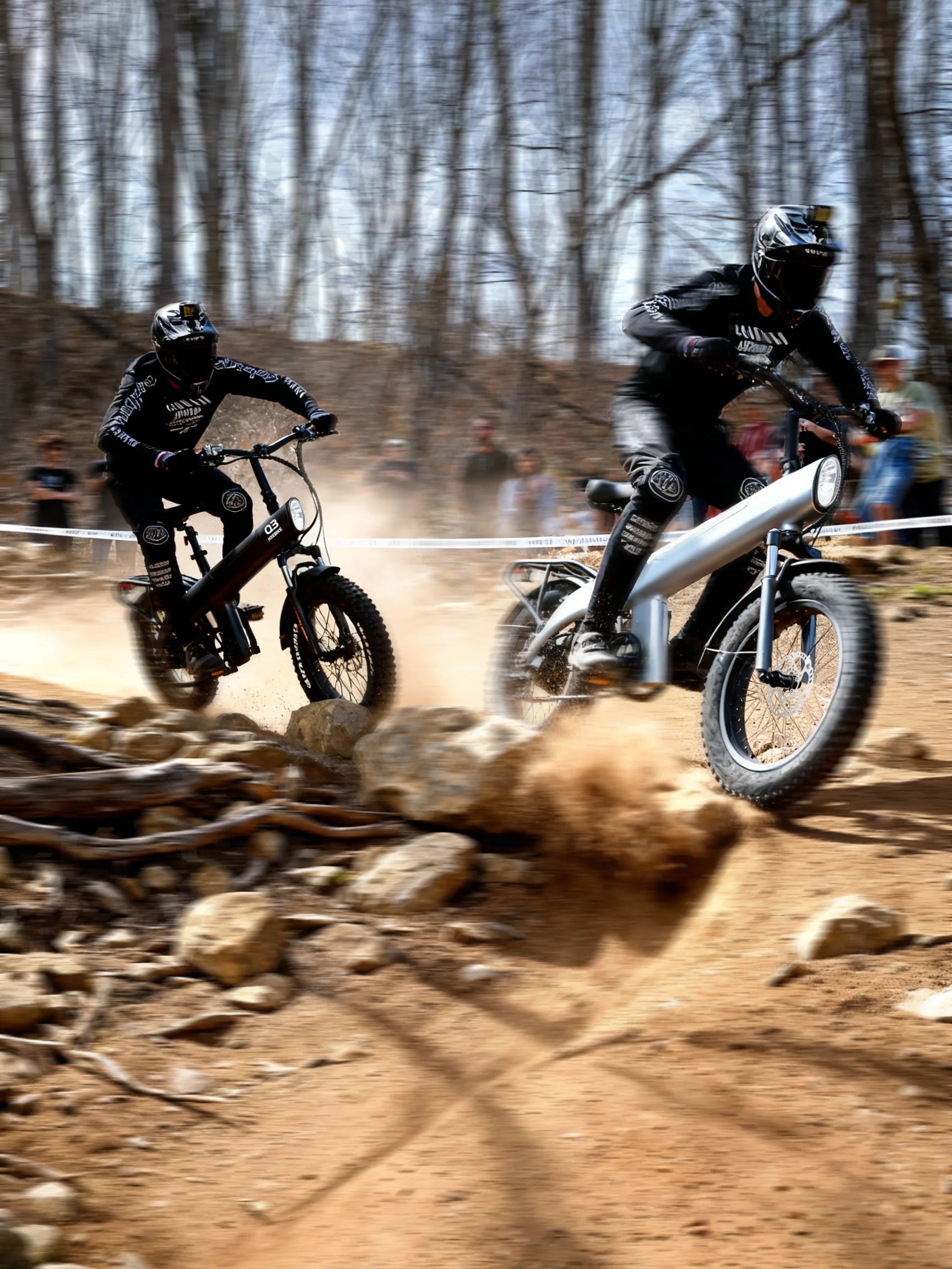 Two dirt bike riders racing on a rocky trail with trees in the background