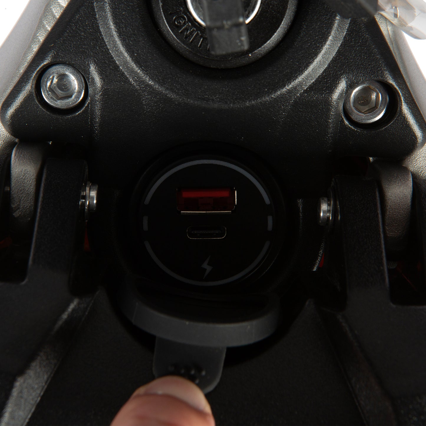 Close-up of a motorcycle fuel tank with a USB charging port.