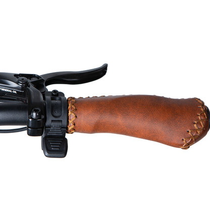 Close-up of a brown leather handlebar grip on a bicycle with black brake lever.