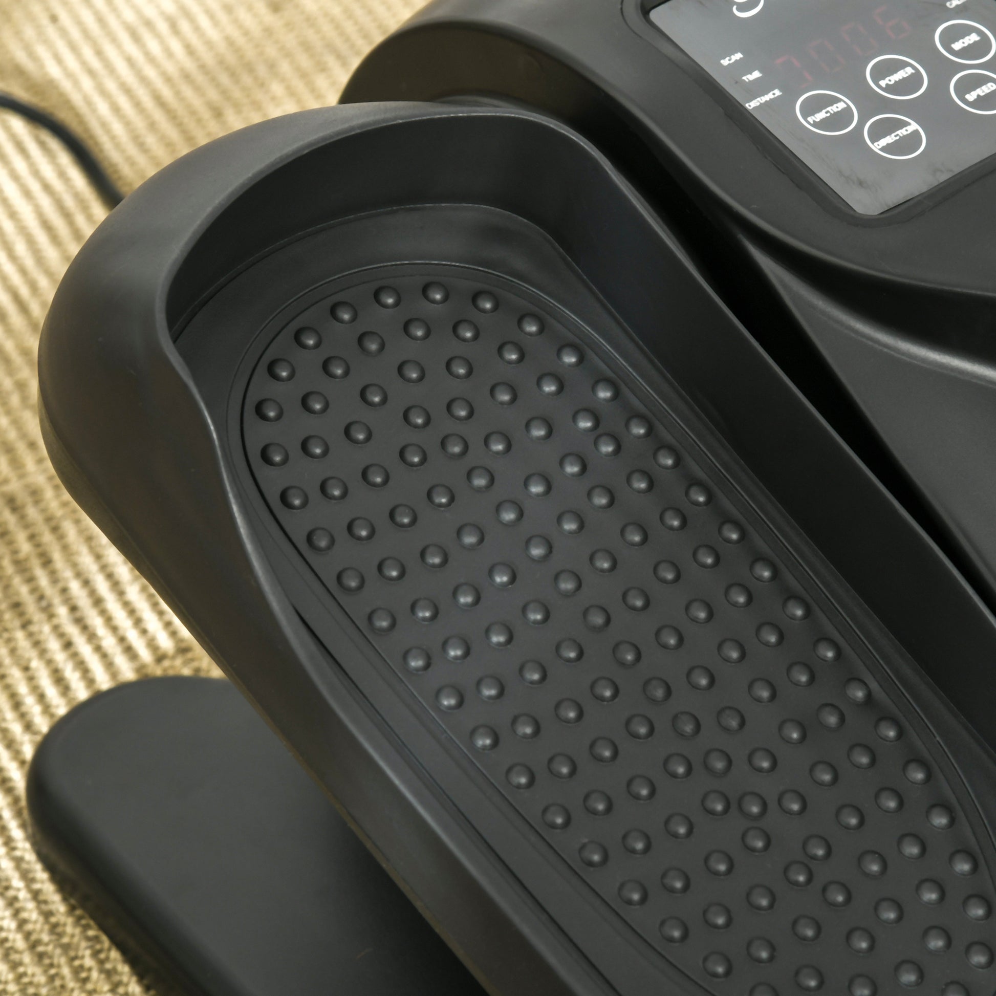 Close-up of a black textured step platform on a piece of exercise equipment.